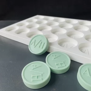 Molde de silicona personalizado para jabones con logotipo, mostrando pieza de jabón en mano y cavidades del molde profesional
